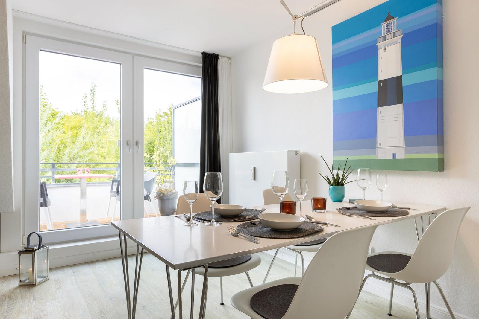 Dining room with table, chairs, and view of balcony