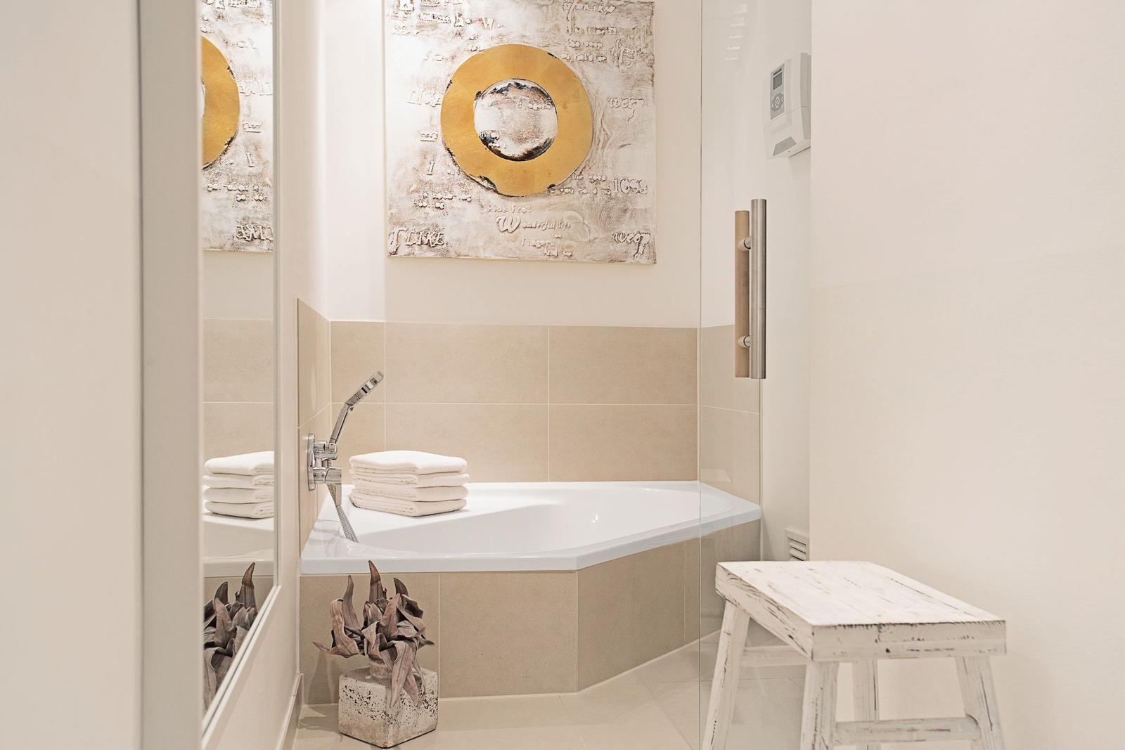 Bad mit Dusche, Badewanne und Holzbank