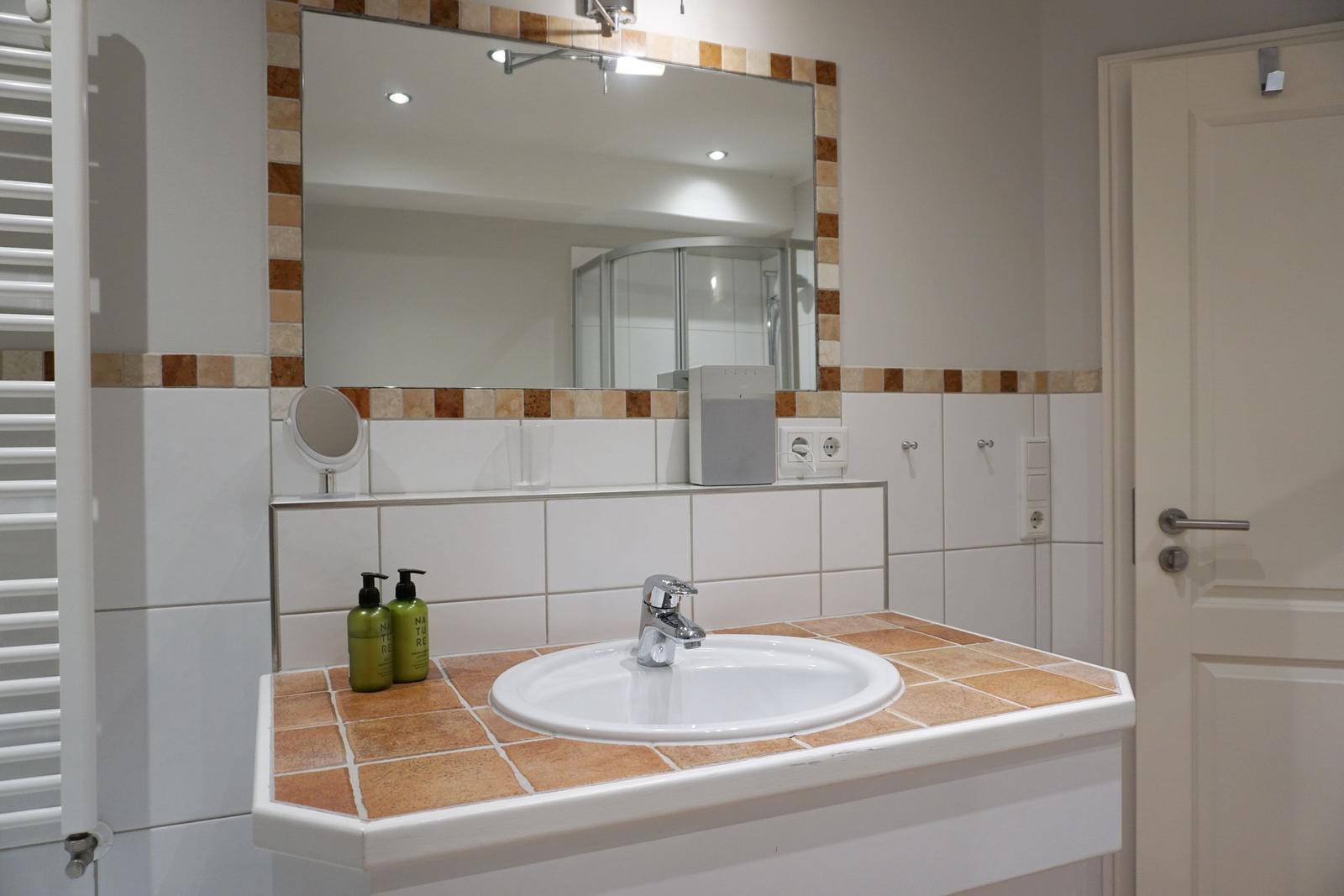 Bad mit Waschbecken, Spiegel und Dusche