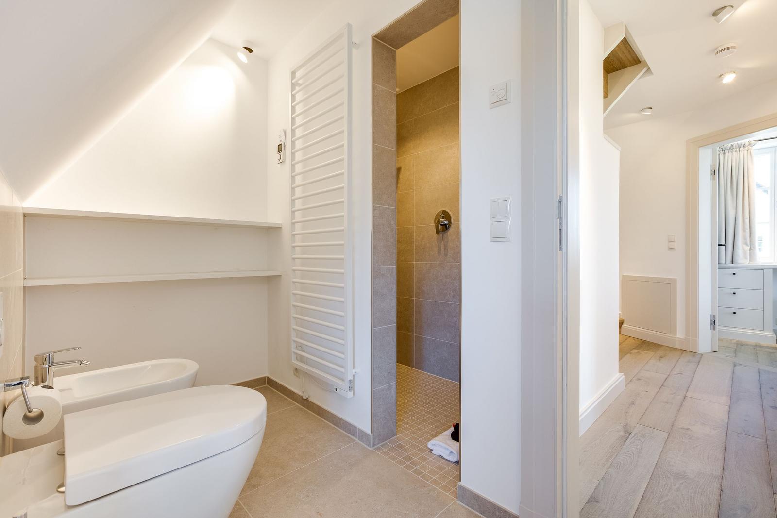 Badezimmer mit Dusche, Toilette und Waschbecken