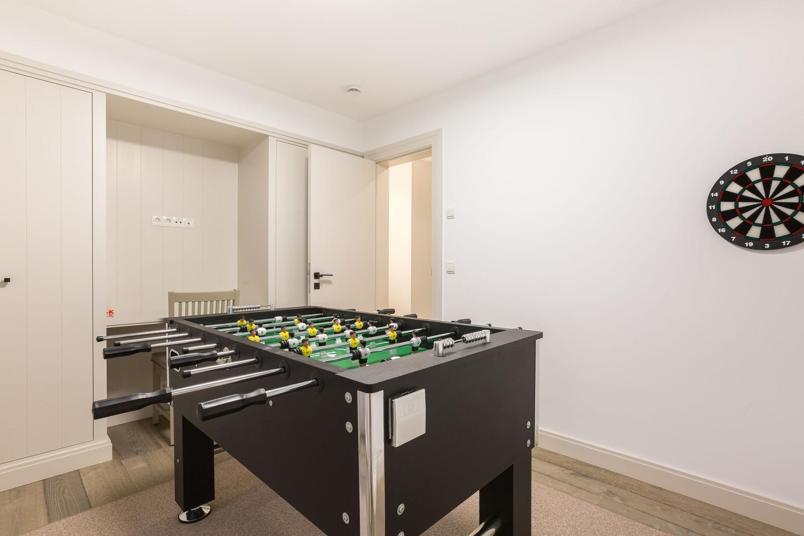 Fussballtisch mit Dartboard an der Wand