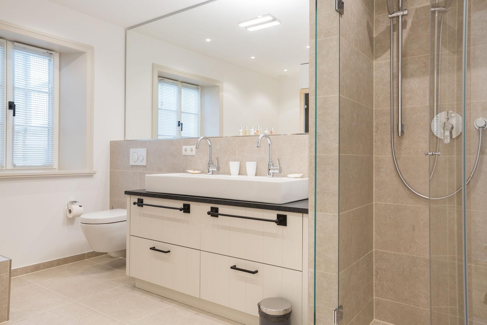 Badezimmer mit Dusche, Waschbecken und Toilette