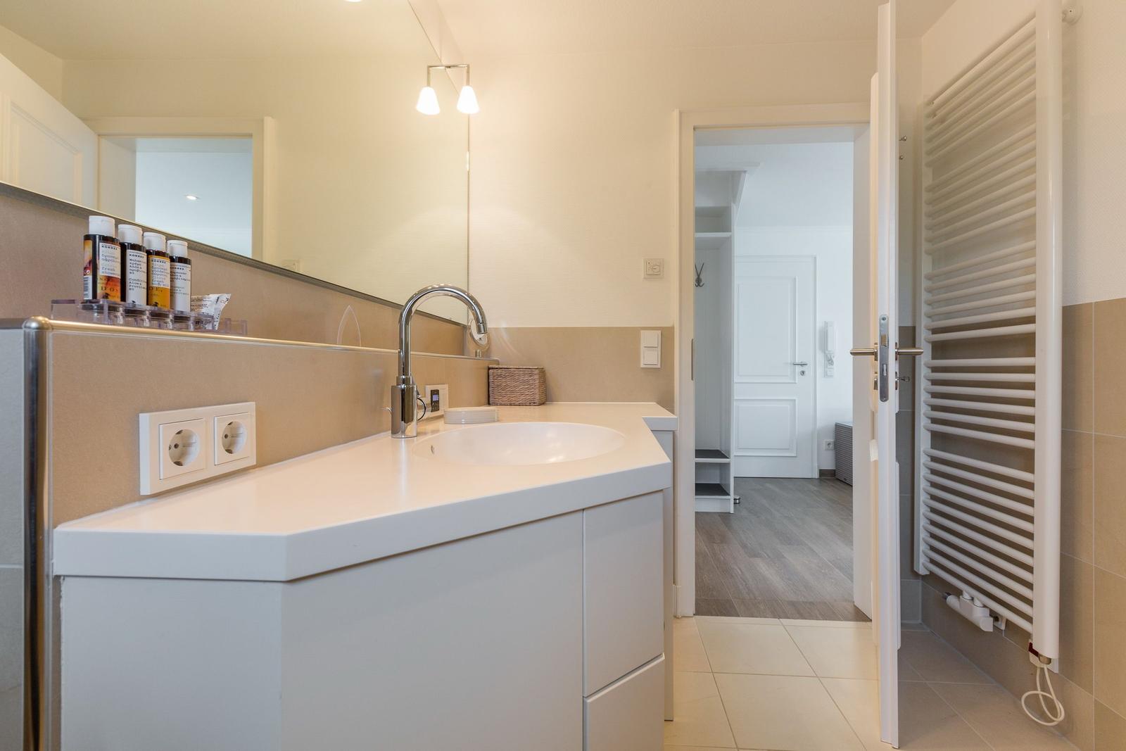 Bathroom with sink, mirror, and radiator