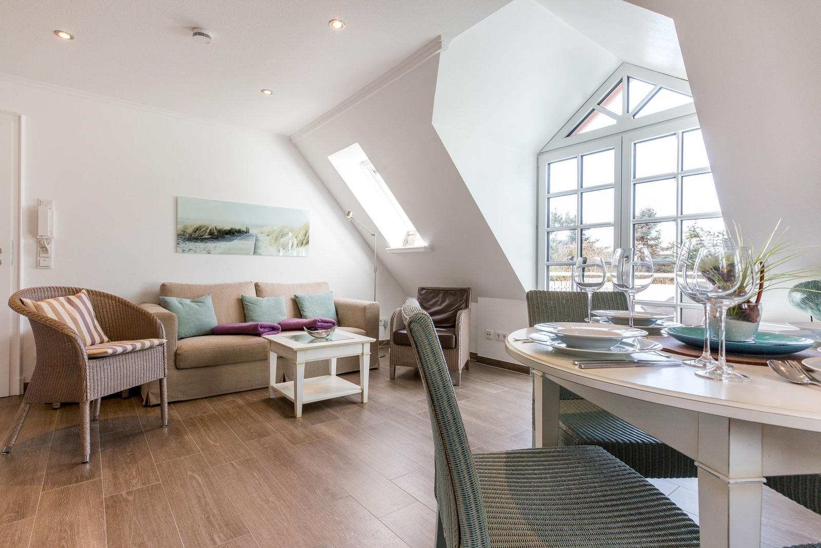 Living and dining area with sofa, table, and windows
