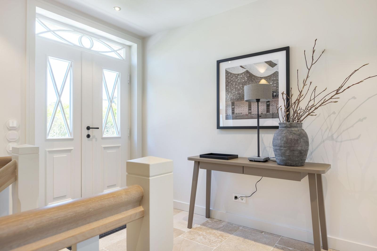 Entrance area with table, lamp, and picture on the wall.