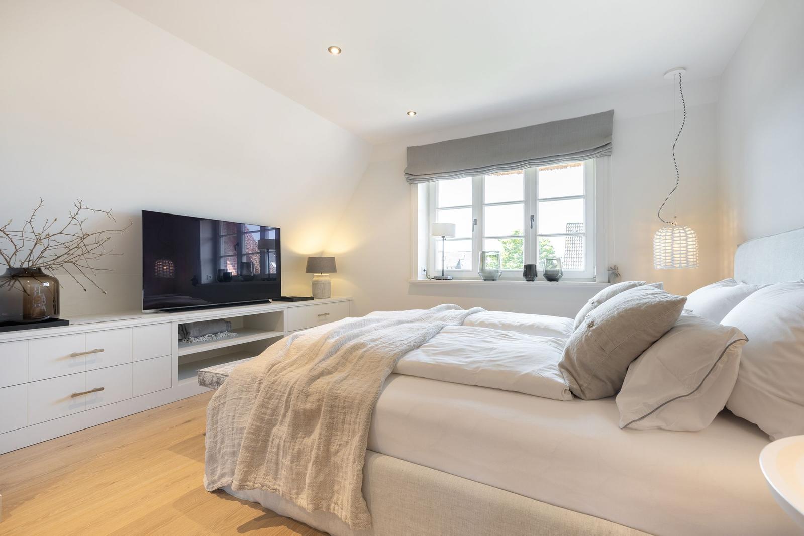 Bedroom with bed, TV, and window