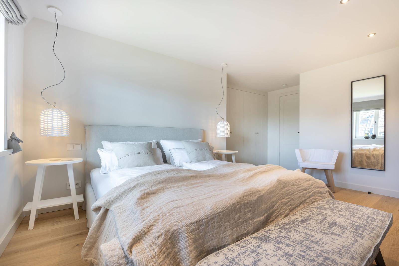 Bedroom with bed, nightstands, and mirror on the wall.