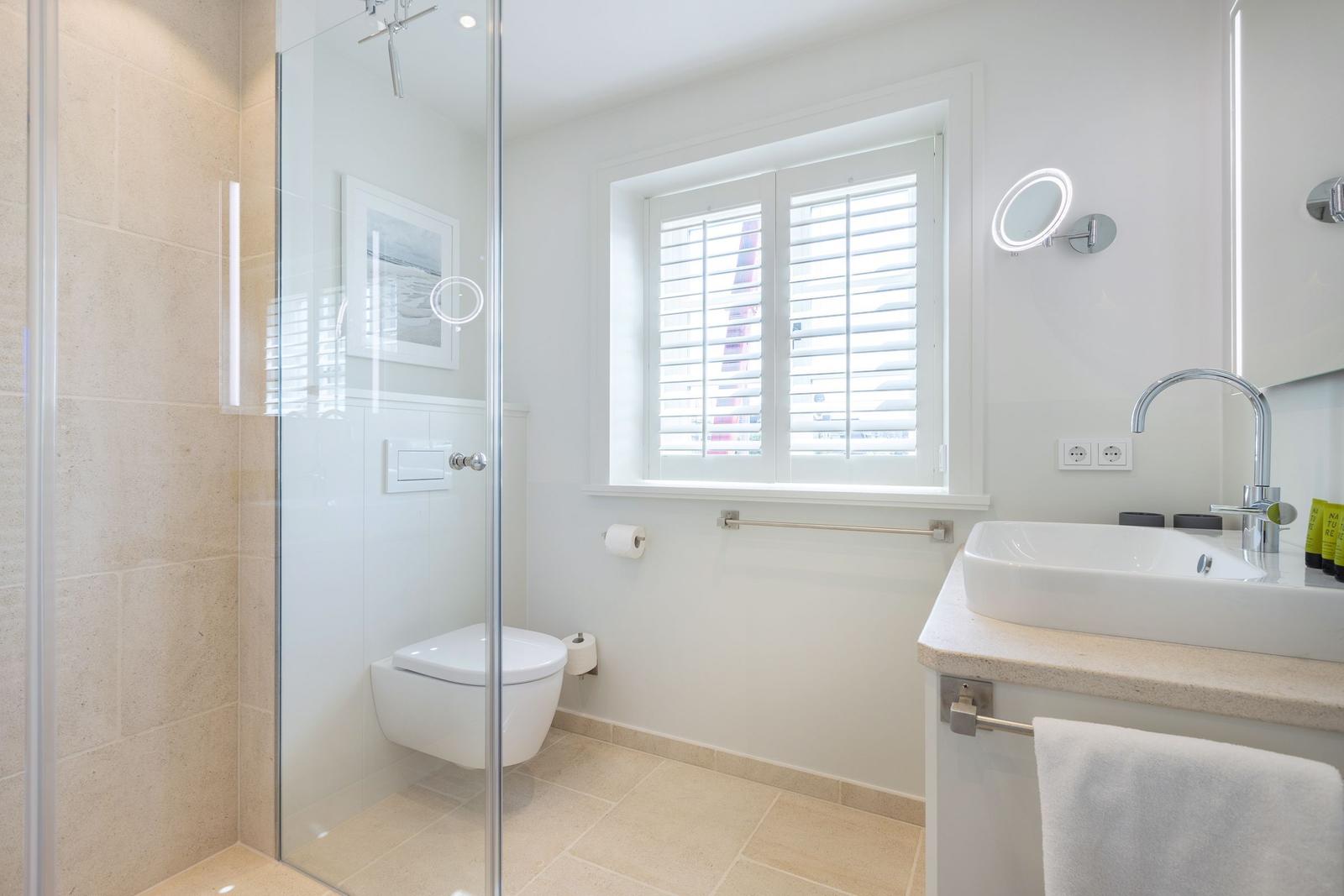 Bathroom with shower, toilet, and sink.