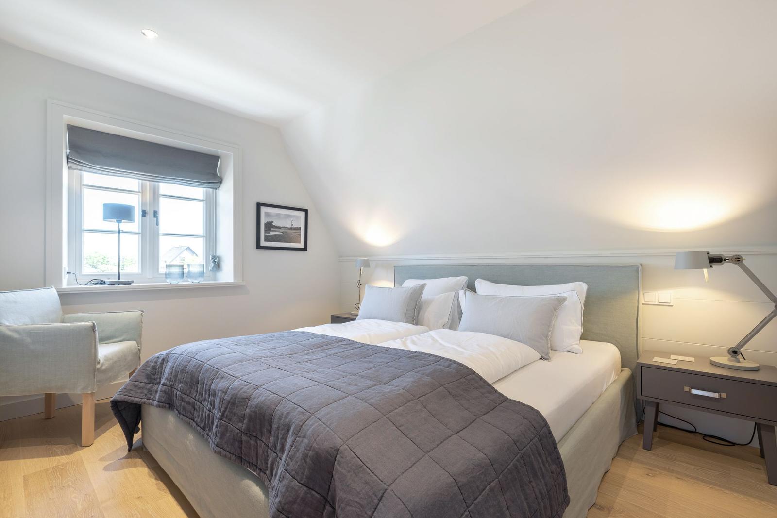 Bedroom with double bed, nightstand, and window view.