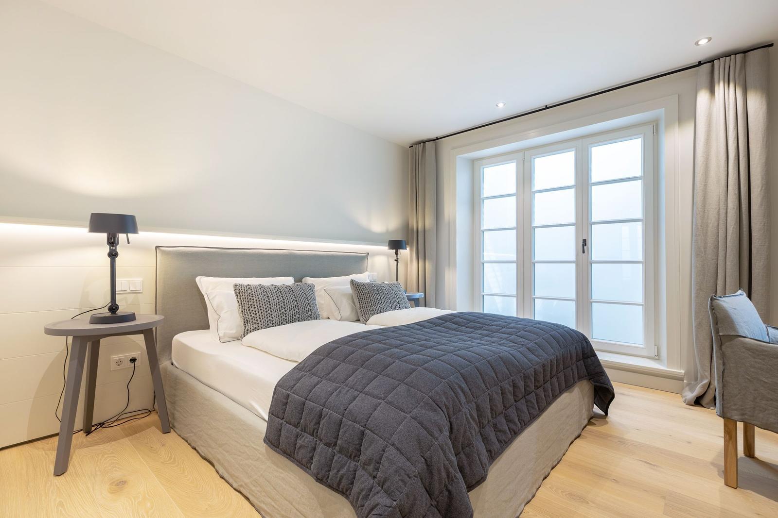 Bedroom with double bed, window, and bedside table.