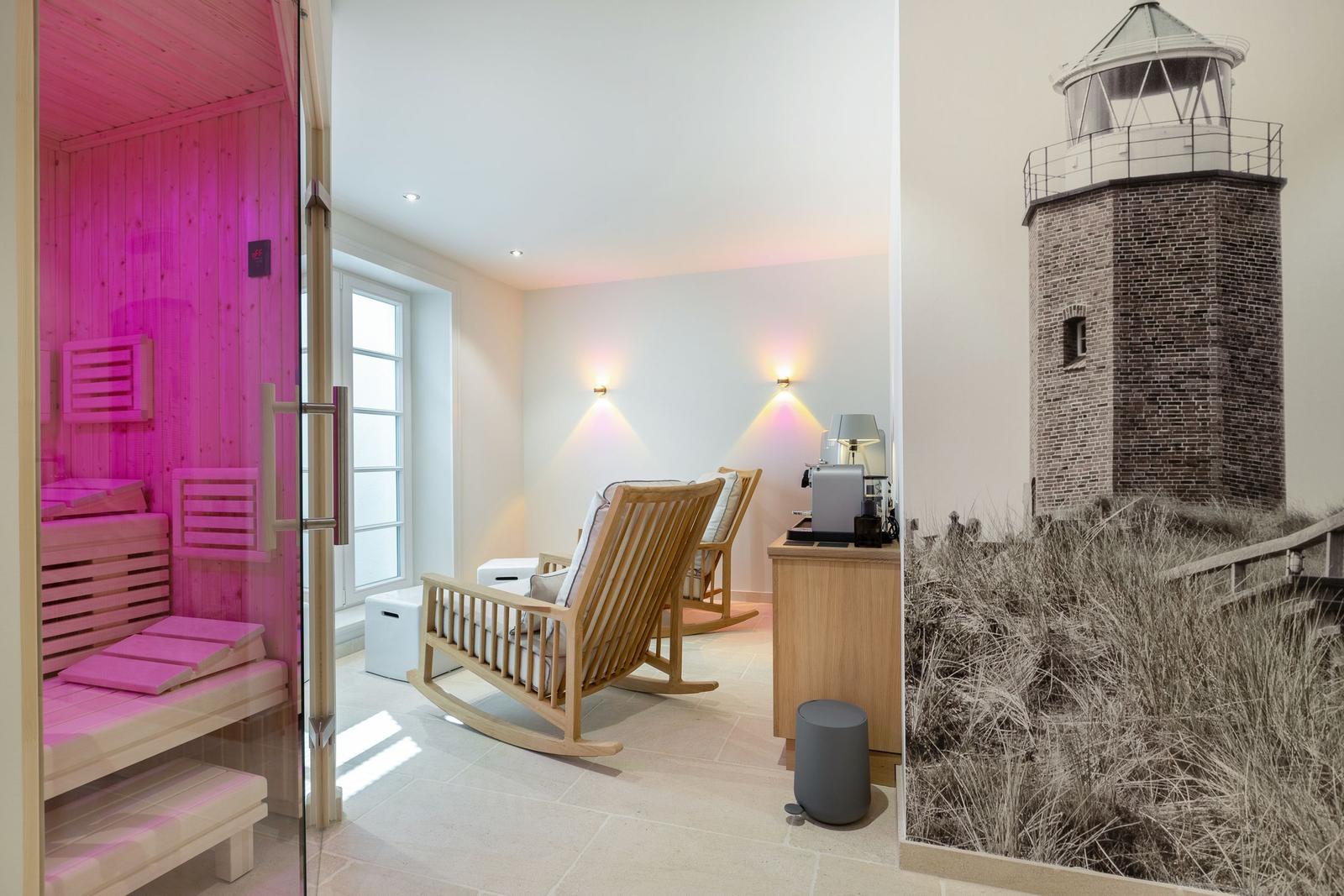 Sauna with pink lighting, two wooden rocking chairs, and lighthouse wall mural.