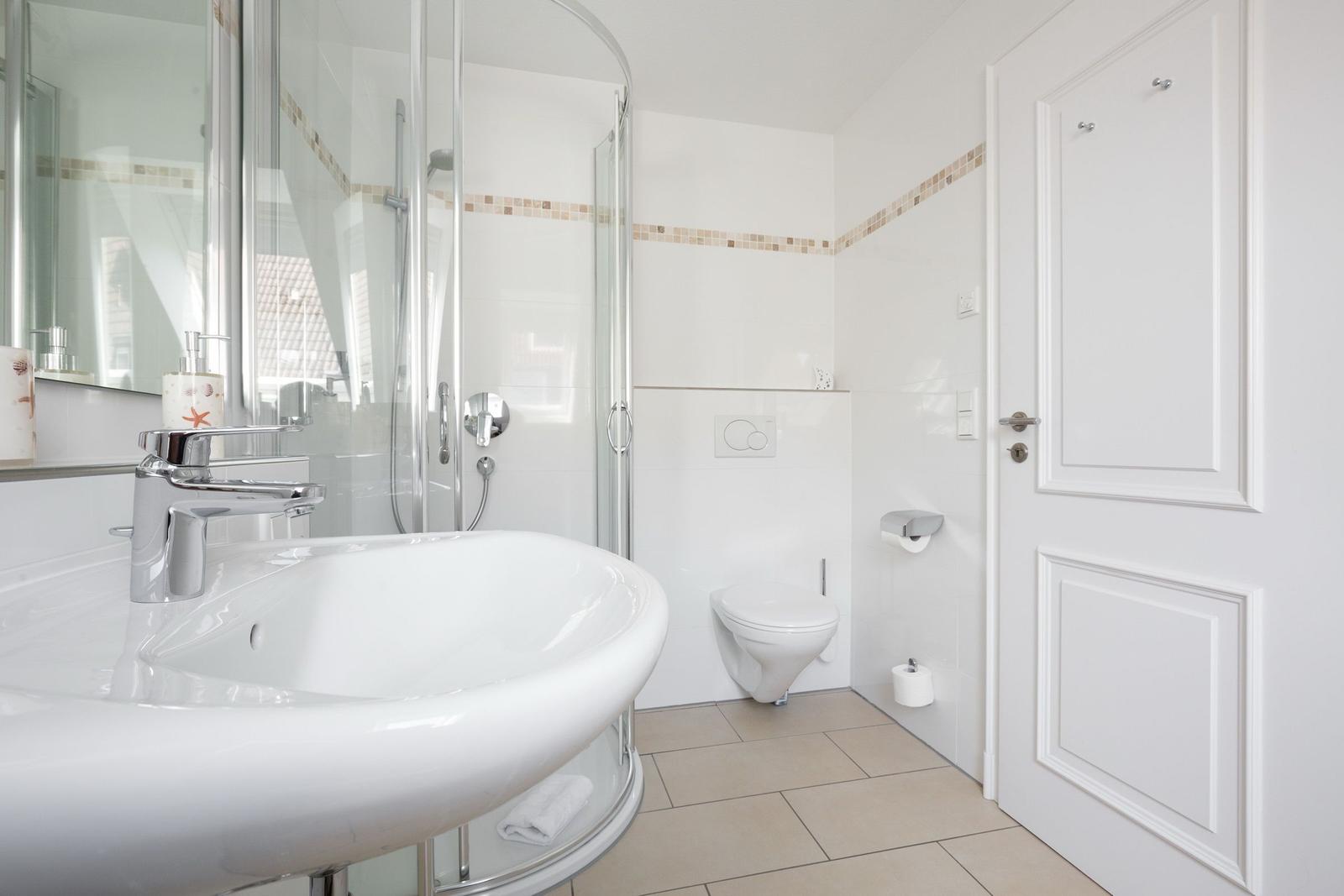 Badezimmer mit Dusche, Waschbecken und WC
