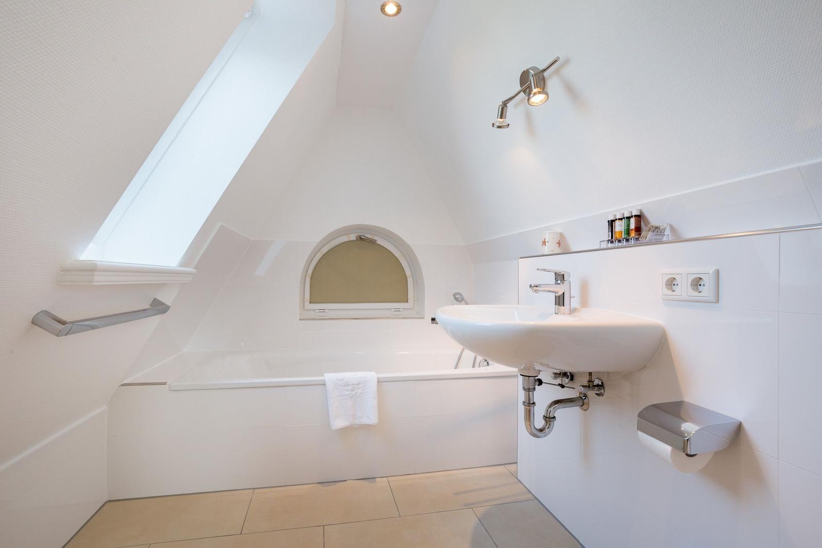 Badezimmer mit Dusche, Waschbecken und Fenster
