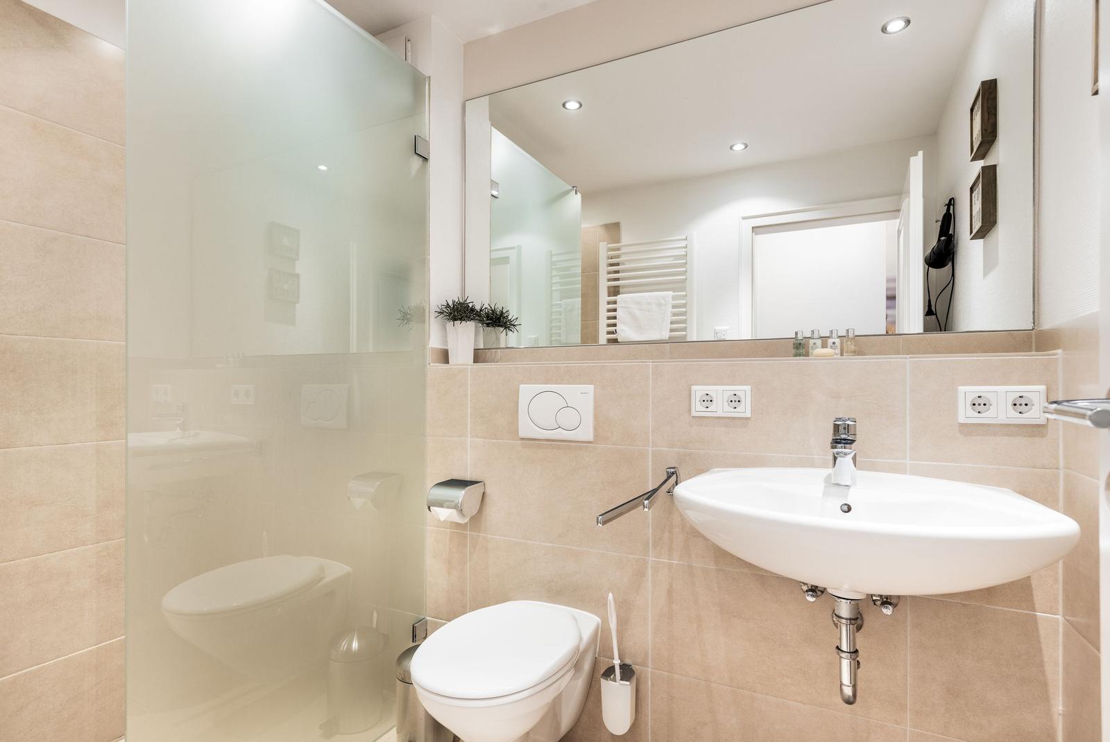 Bathroom with shower, toilet, and sink.