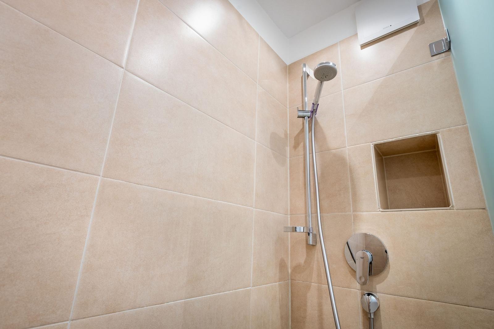 Shower with handheld showerhead and built-in shelf