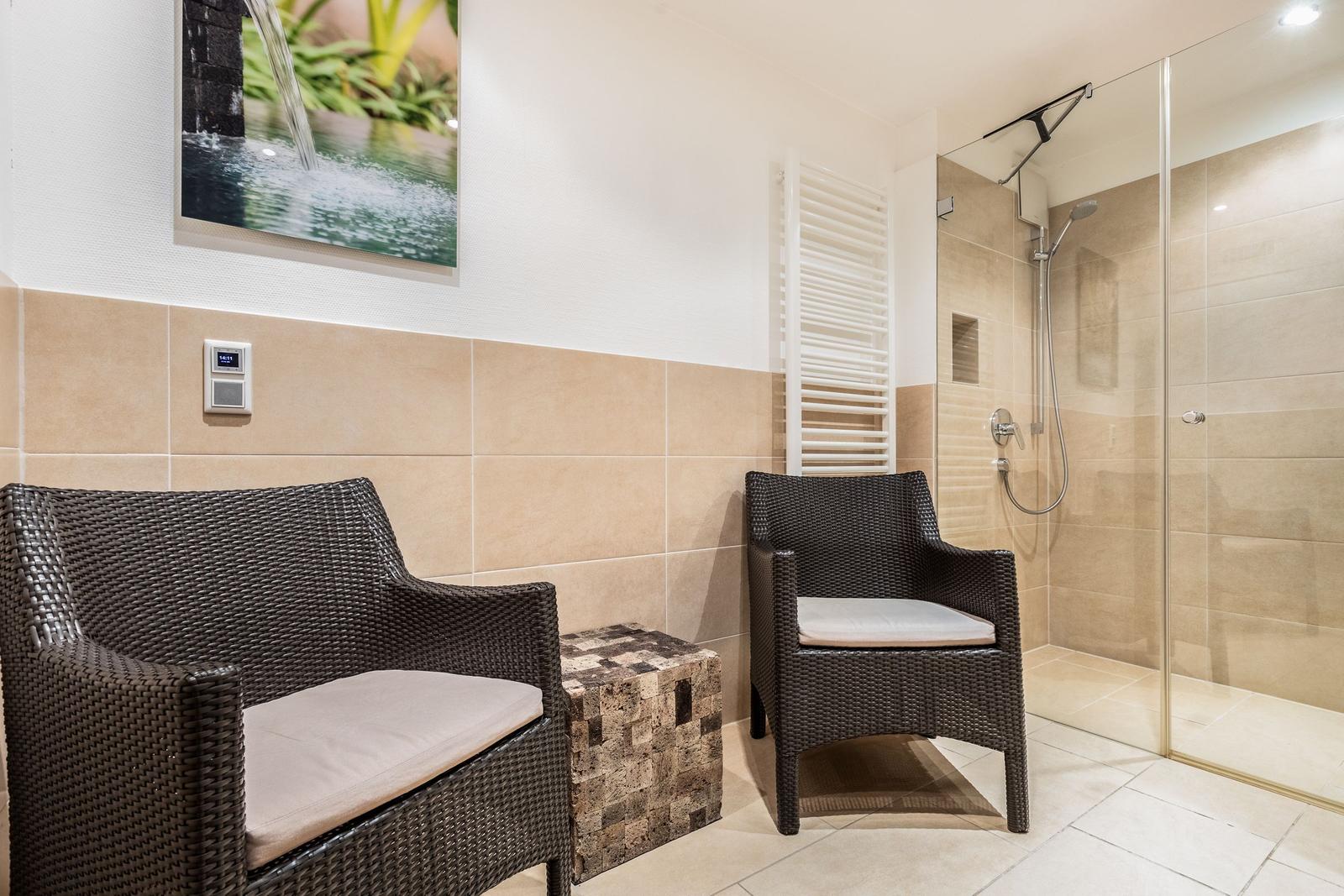 Bath with shower, two chairs, and wall picture