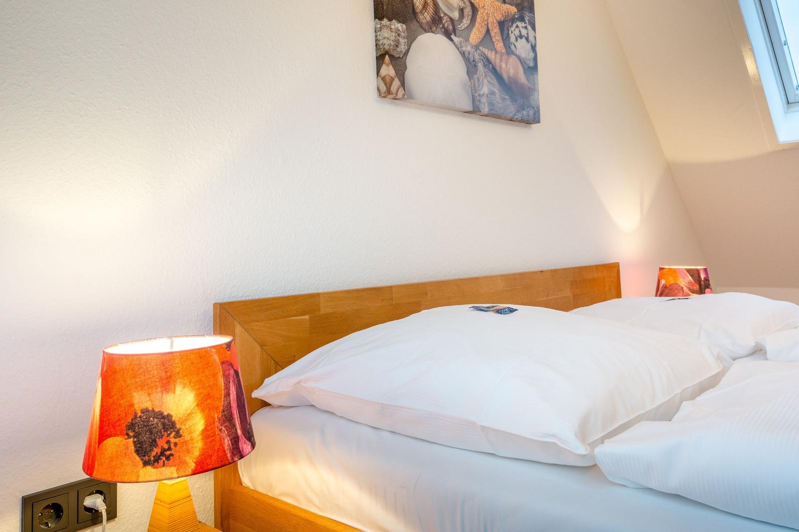Schlafzimmer mit Bett, Nachttisch und Wandbild