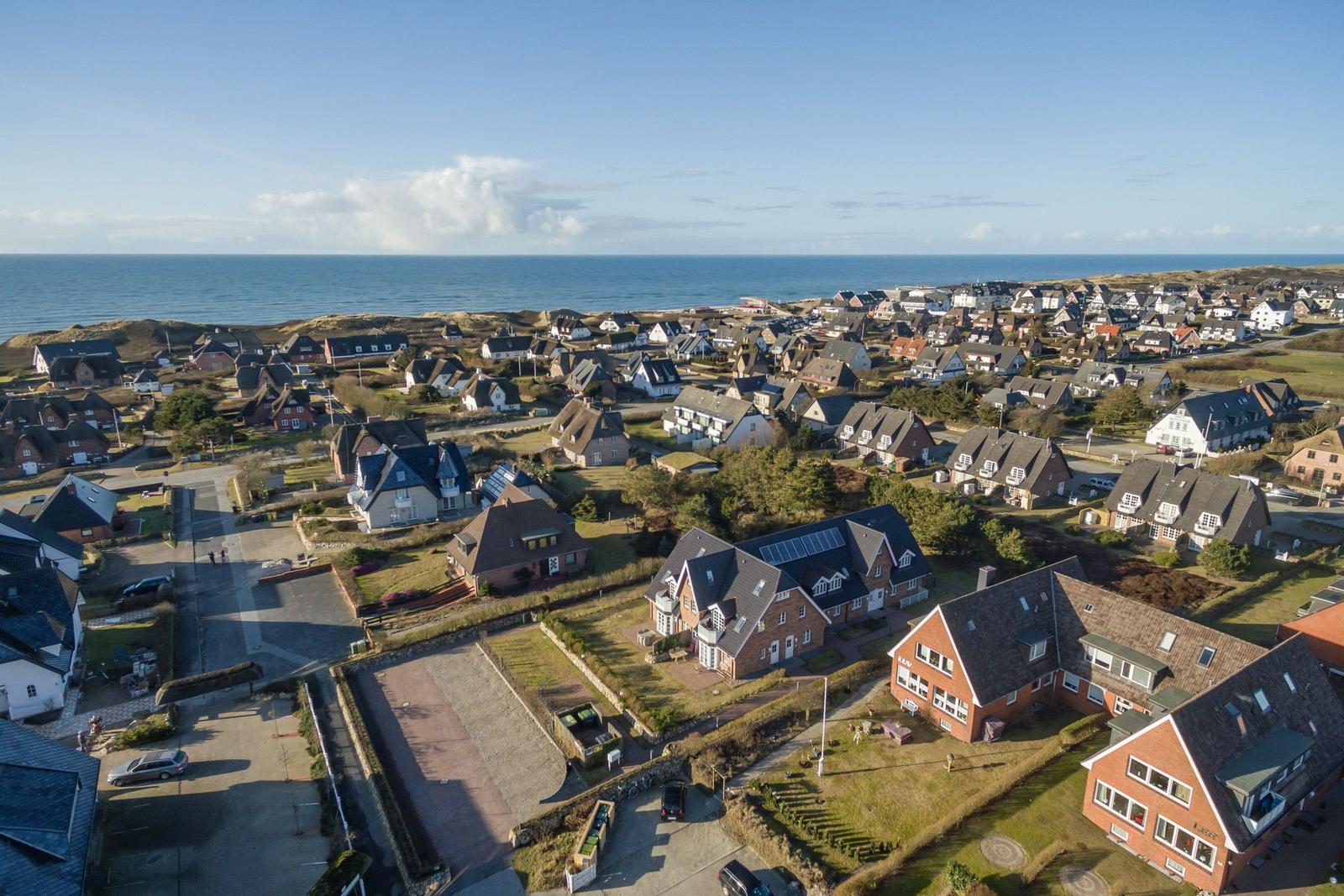 Aerial view of a coastal village with houses near the sea.