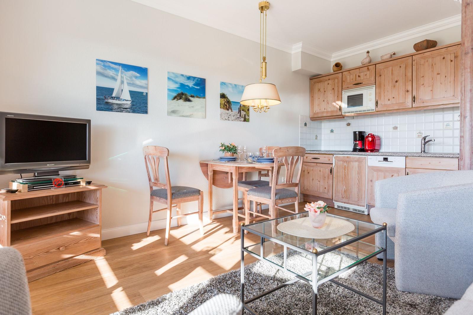 Living kitchen with wooden furniture, dining area, and TV.