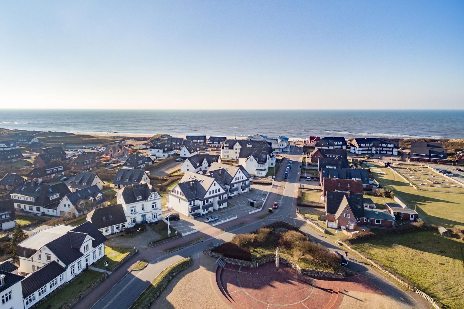 Aerial view of coastal village with houses near the sea.