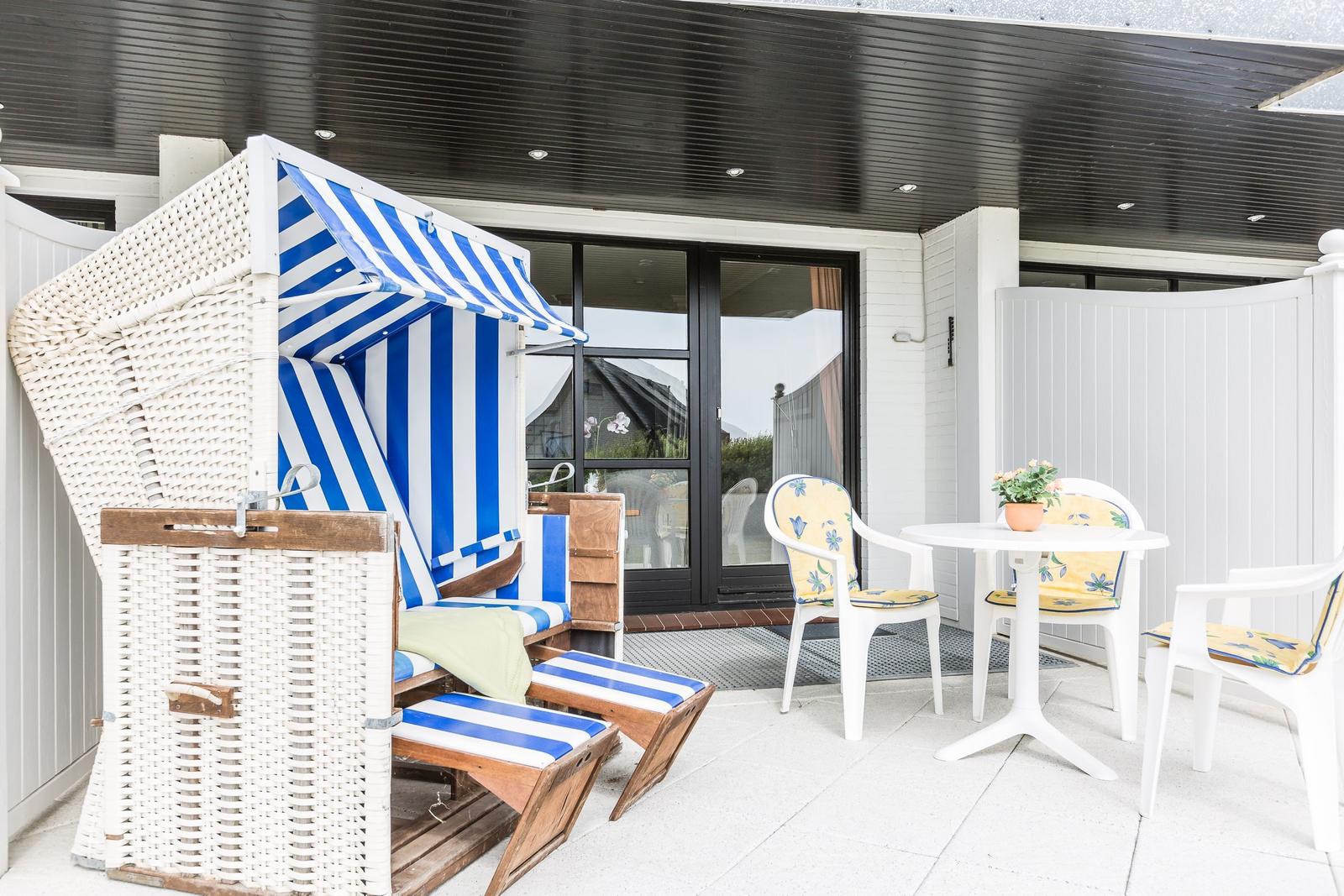 Terrace with beach chair, table and chairs under roof