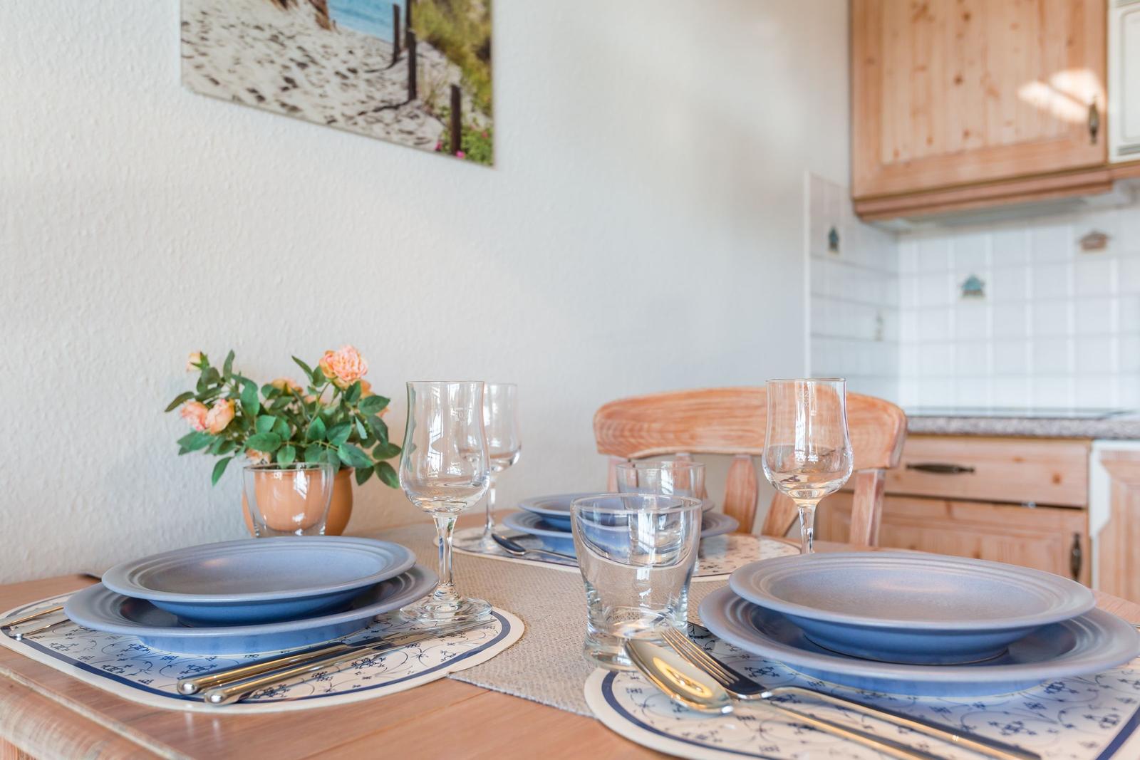Table set with blue plates, glasses, and flower arrangement.