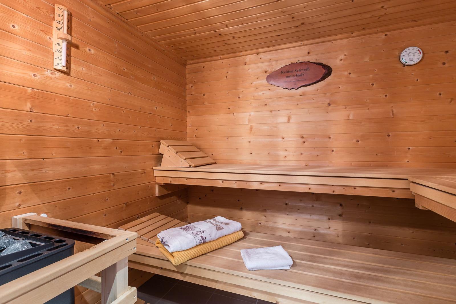 Sauna mit Holzbank, Thermometer und Handtuch