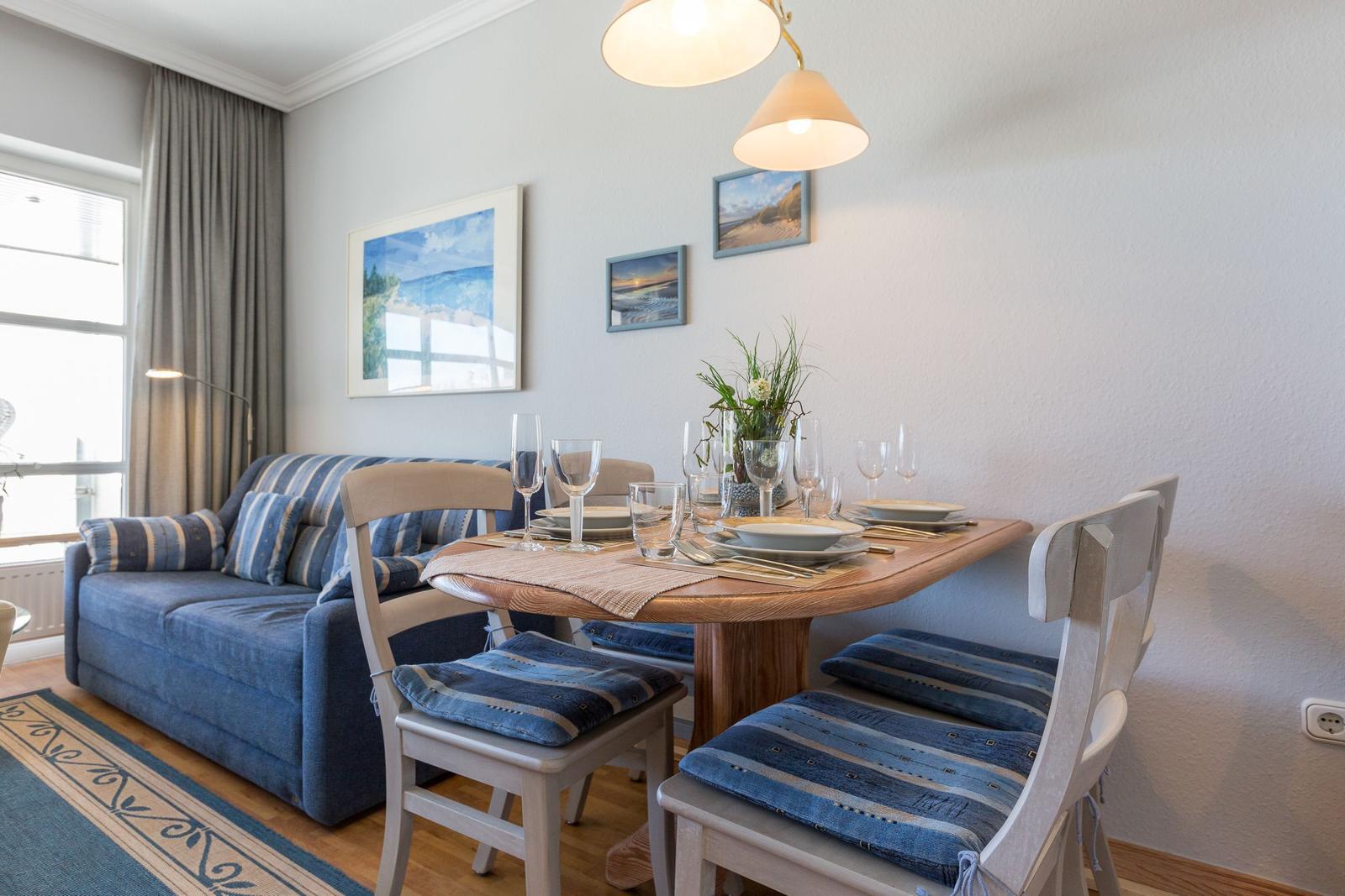 Esstisch mit Stühlen und Sofa im Wohnzimmer.