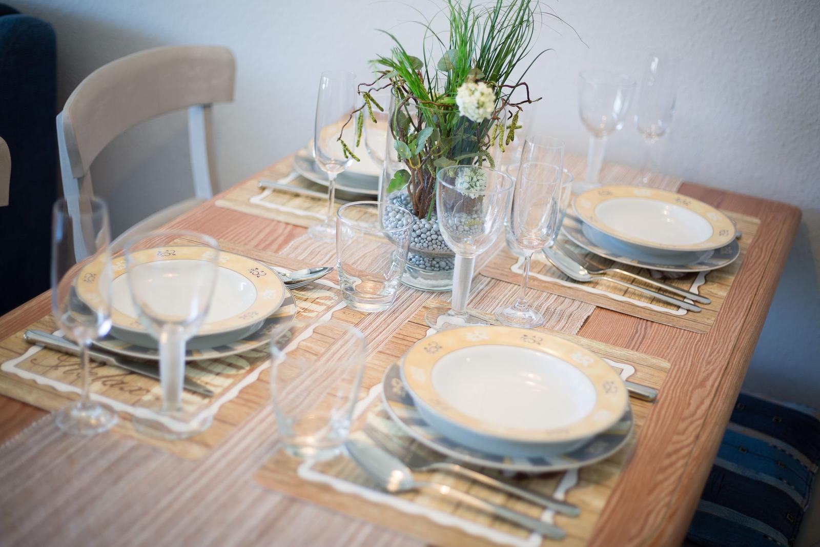 Tisch mit Platzsetzung, Gläsern und Blumendekoration.