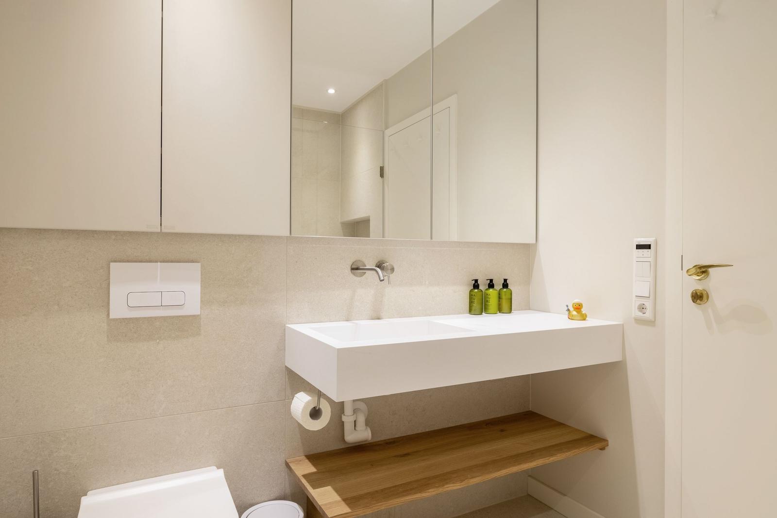 Moderne Badewanne mit Spiegel, Waschbecken und Holzbank