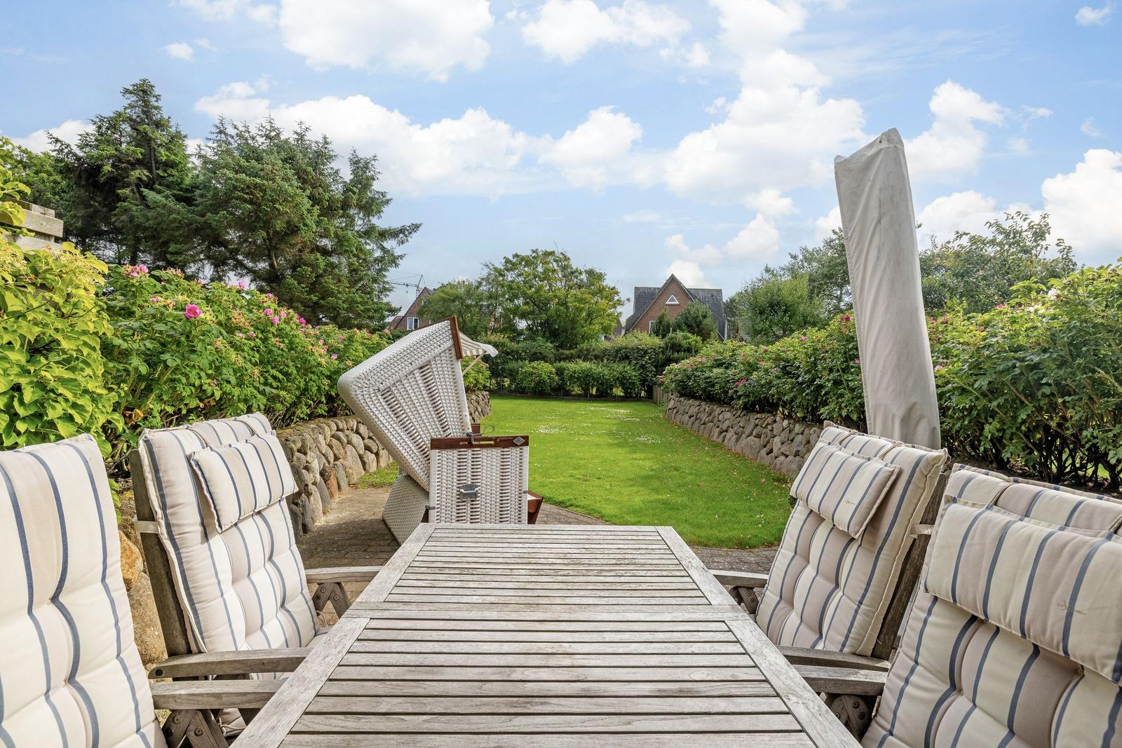 Terrasse mit Sitzgruppe und Blick auf grünen Garten