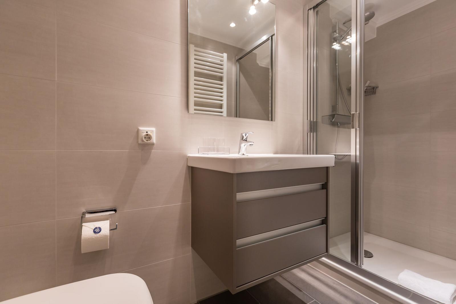 Badezimmer mit Waschbecken, Dusche und Toilette.