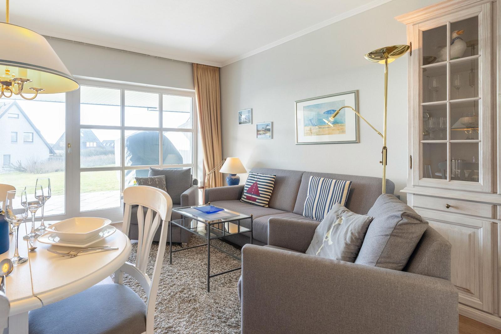 Wohn- und Essbereich mit Sofa, Tisch und Fensterblick.