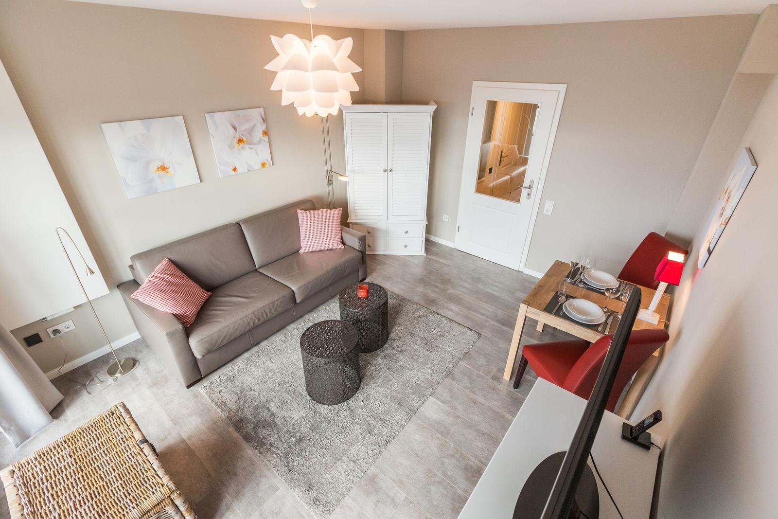 Living room with sofa, dining table, and white cabinets