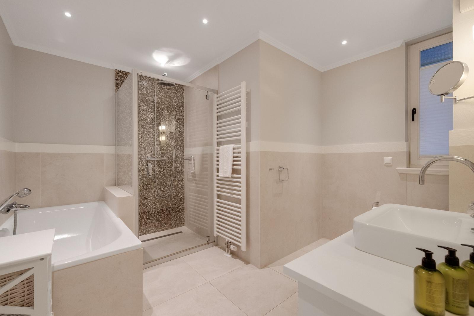 Bathroom with bathtub, shower, and sink.