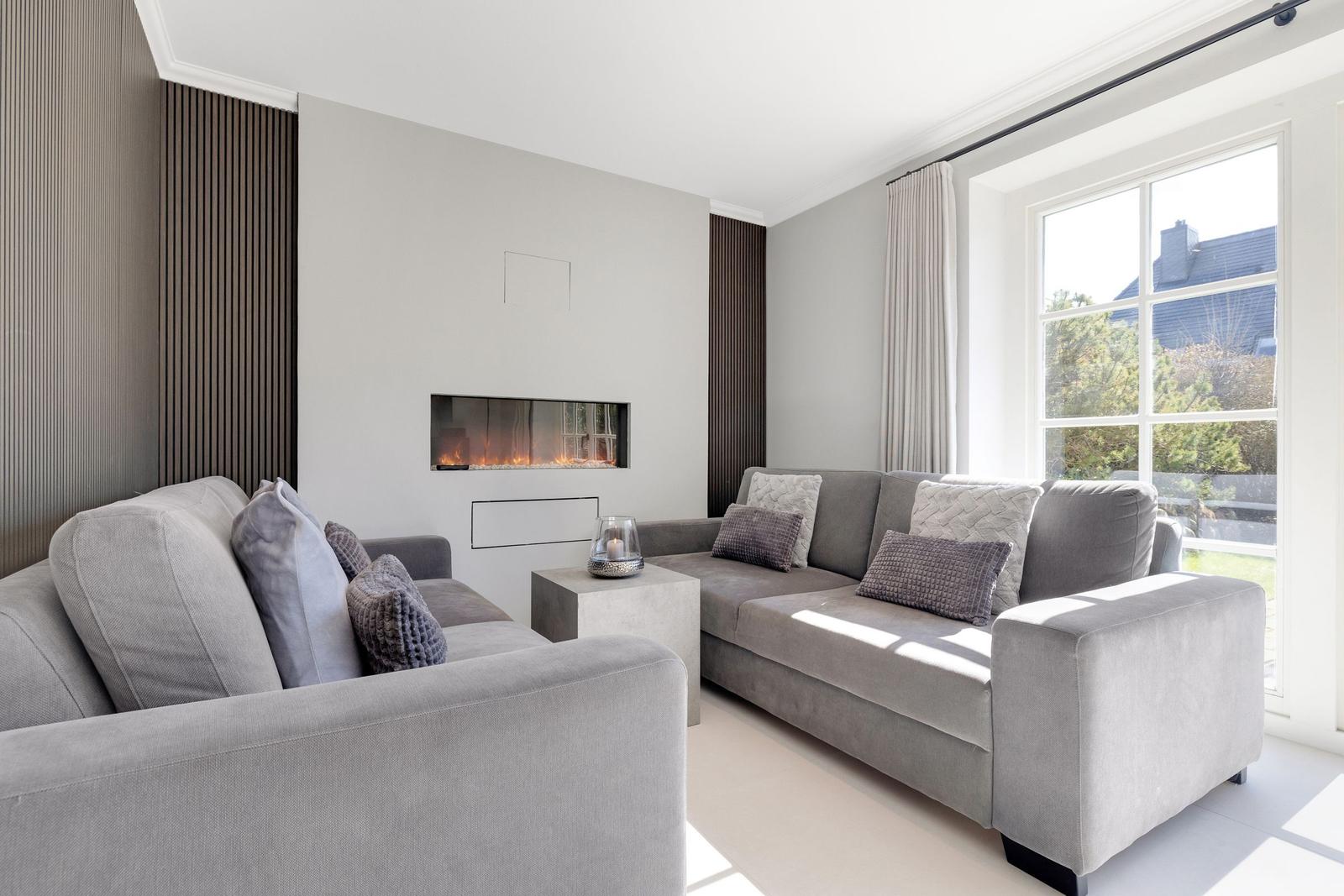Living room with gray sofa, fireplace, and large window.