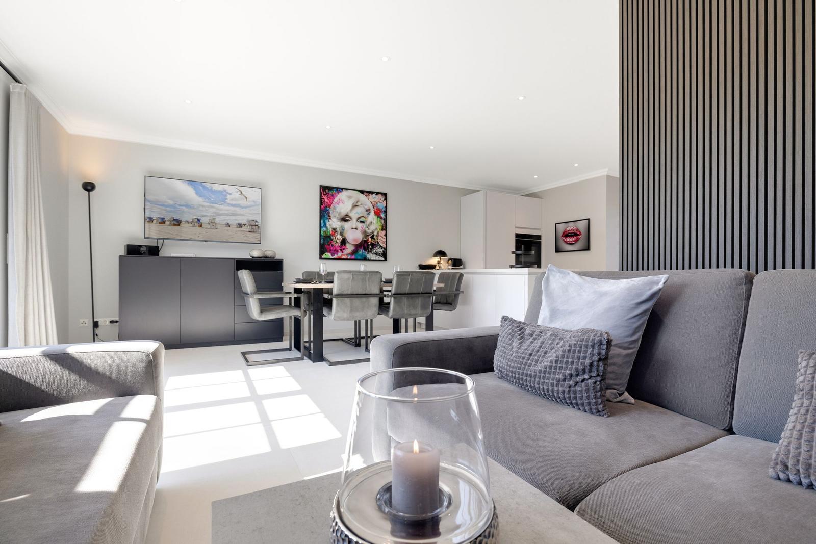 Living room with sofa, dining table, and wall art
