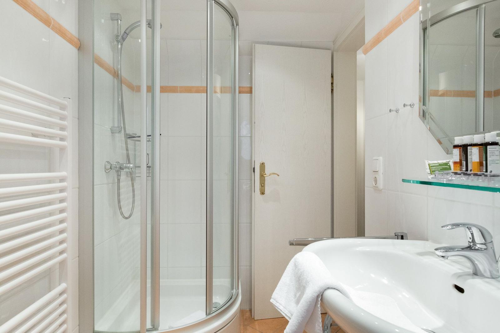 Bathroom with shower cabin, sink, and mirror.