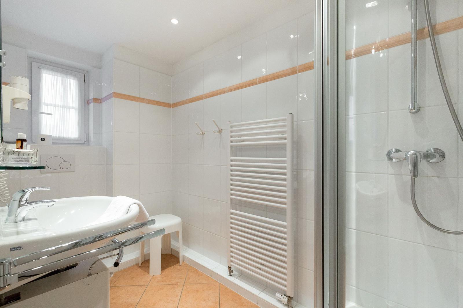 Bathroom with shower, sink, and heater
