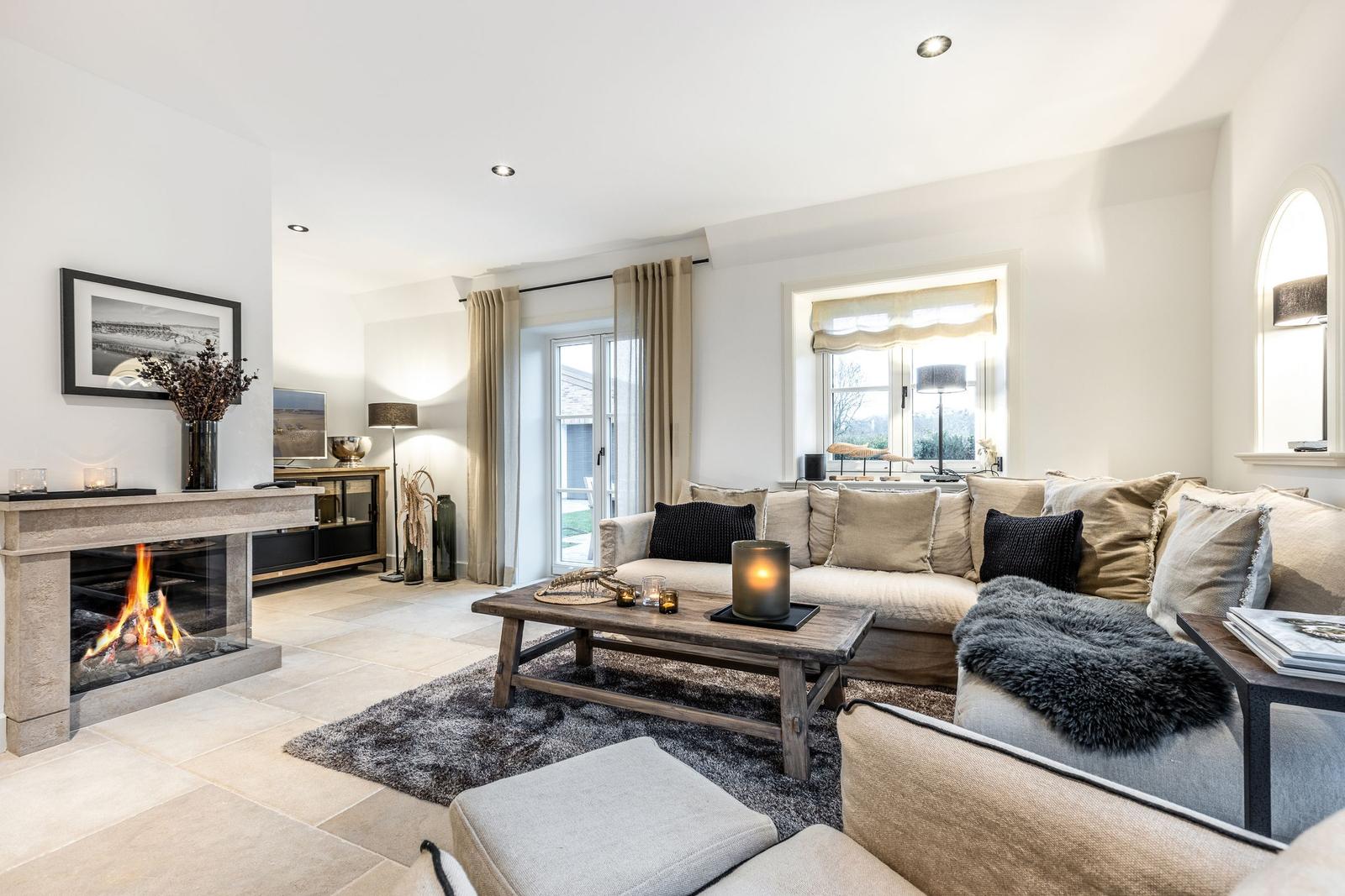 Wohnzimmer mit Kamin, Sofa und Holztisch