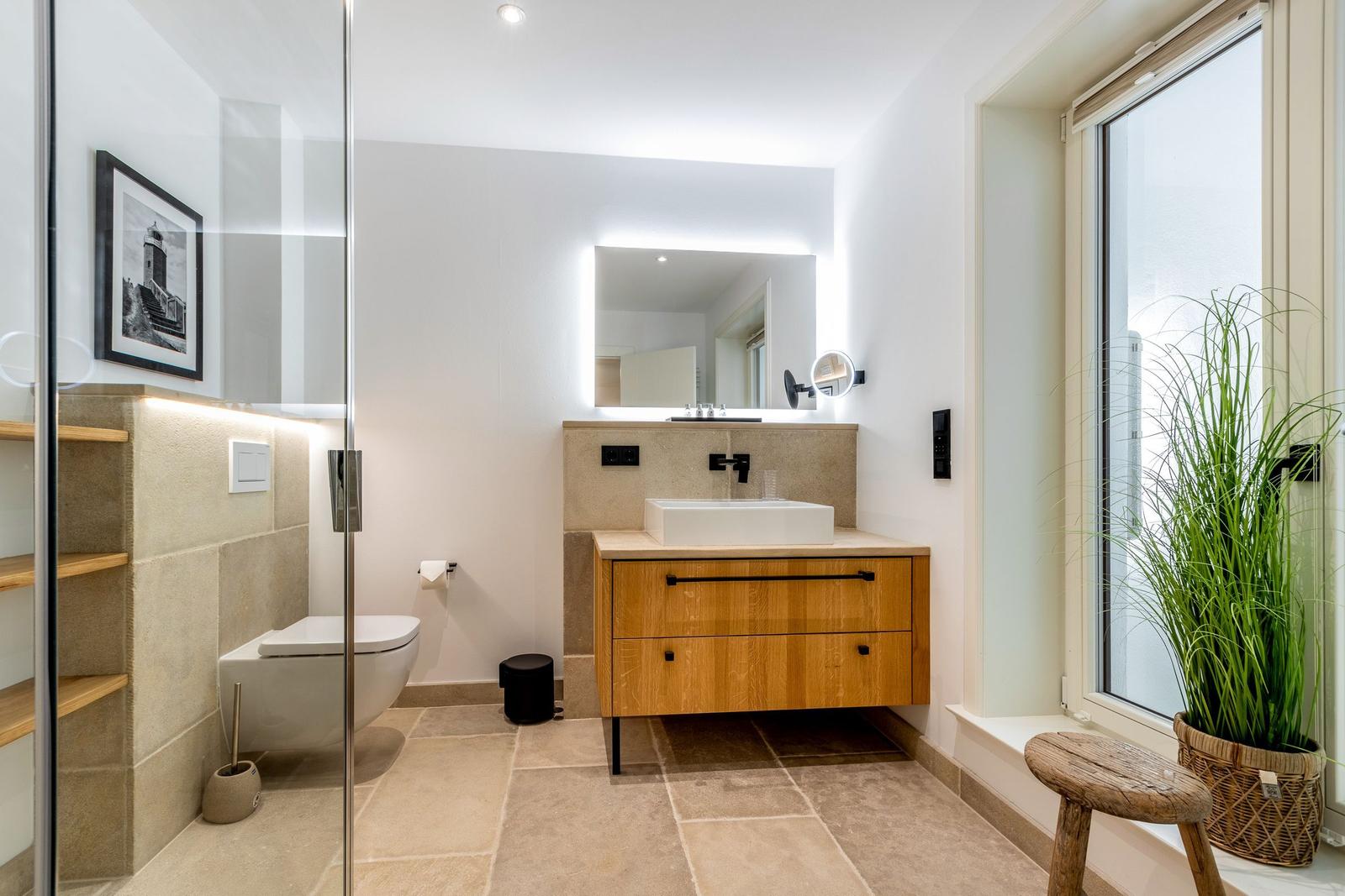 Badezimmer mit Dusche, Waschbecken und Fenster