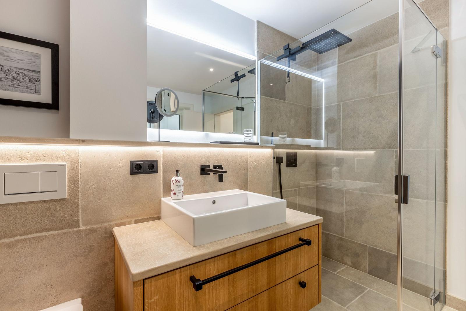 Bad mit Dusche, Waschbecken und Spiegel