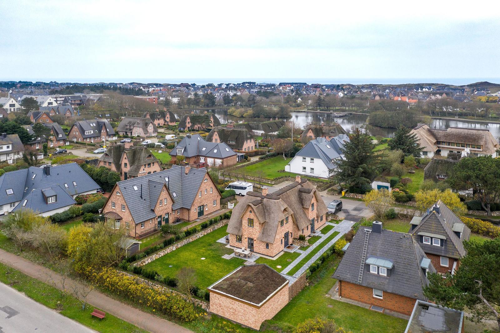 Haus mit Strohdach und Garten in ruhiger Wohngegend mit Wasser und Blick auf die Landschaft.
