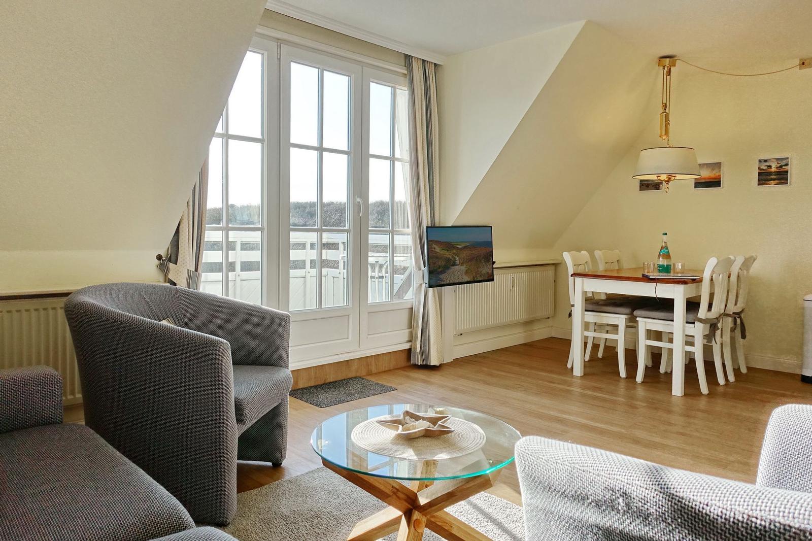 Living and dining area with window, sofa, table and chairs.