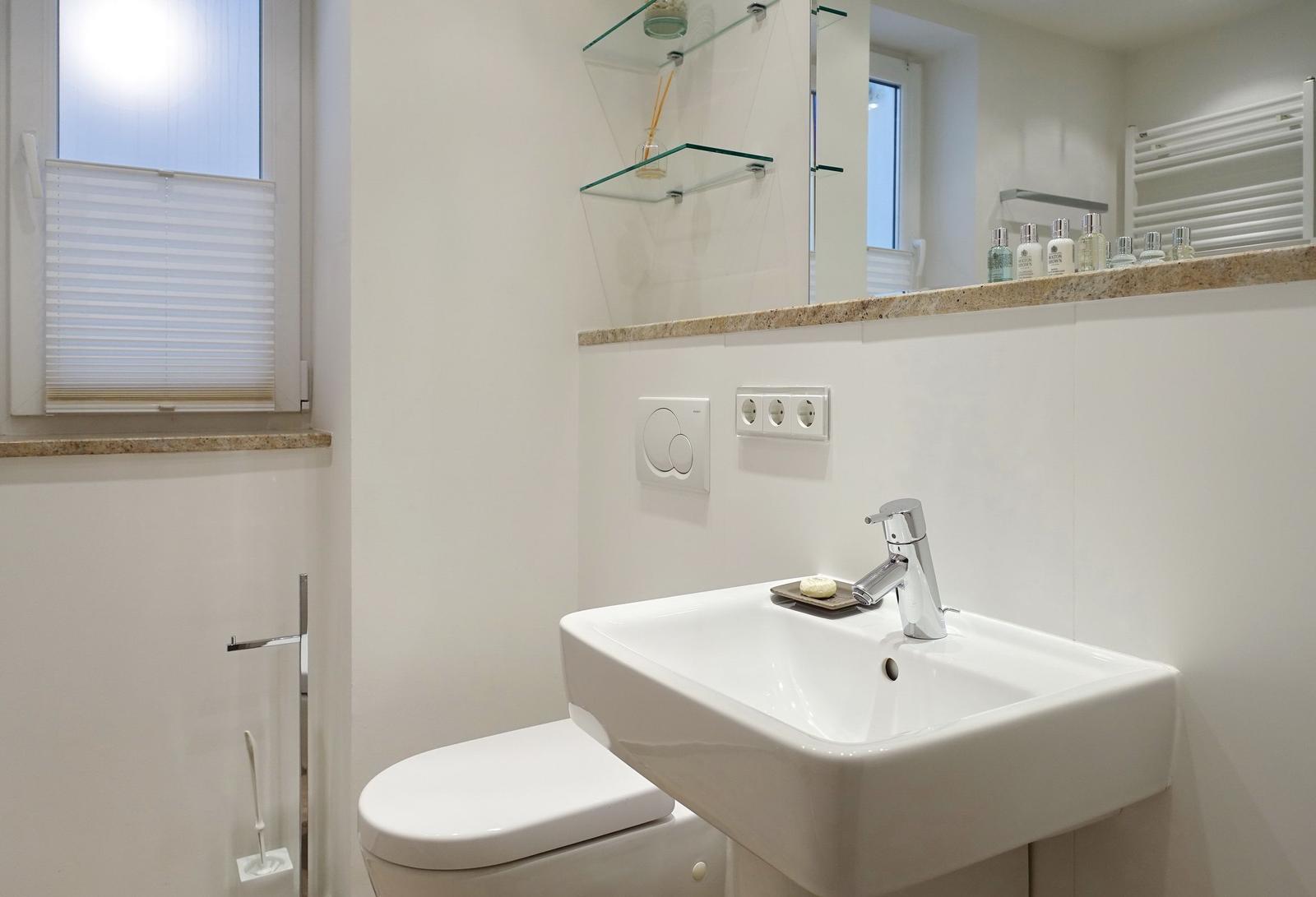 Bathroom with sink, toilet, and mirror cabinet