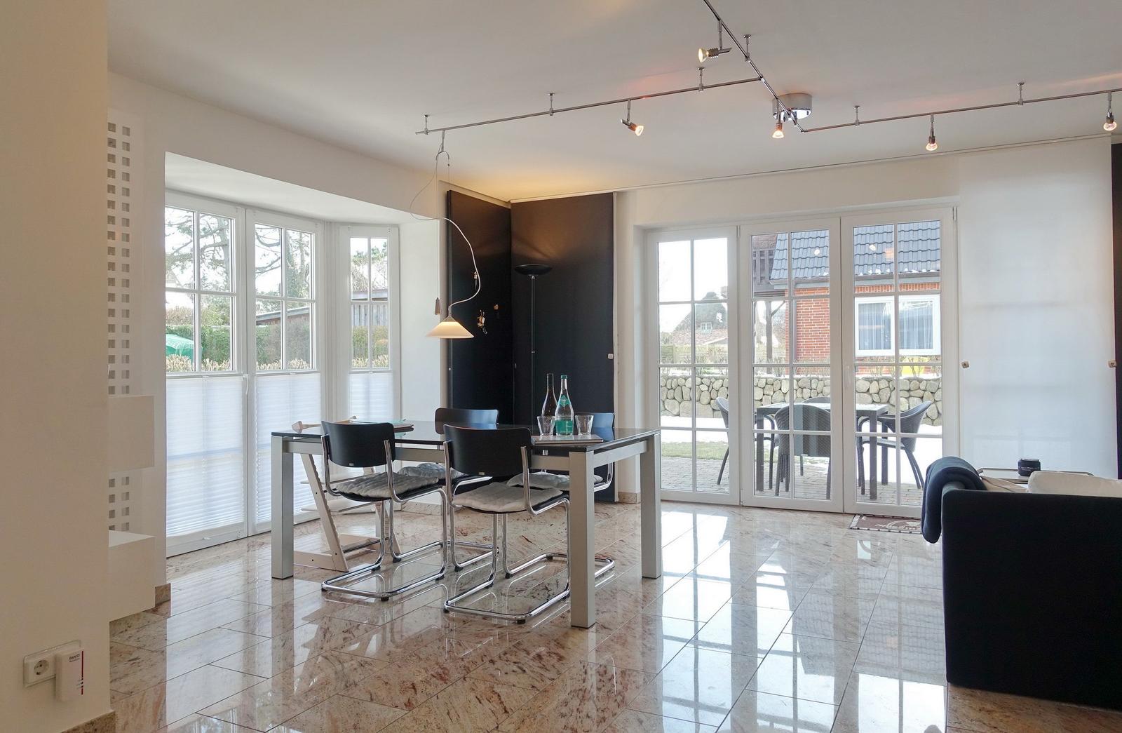 Dining room with table, chairs, and view of garden.