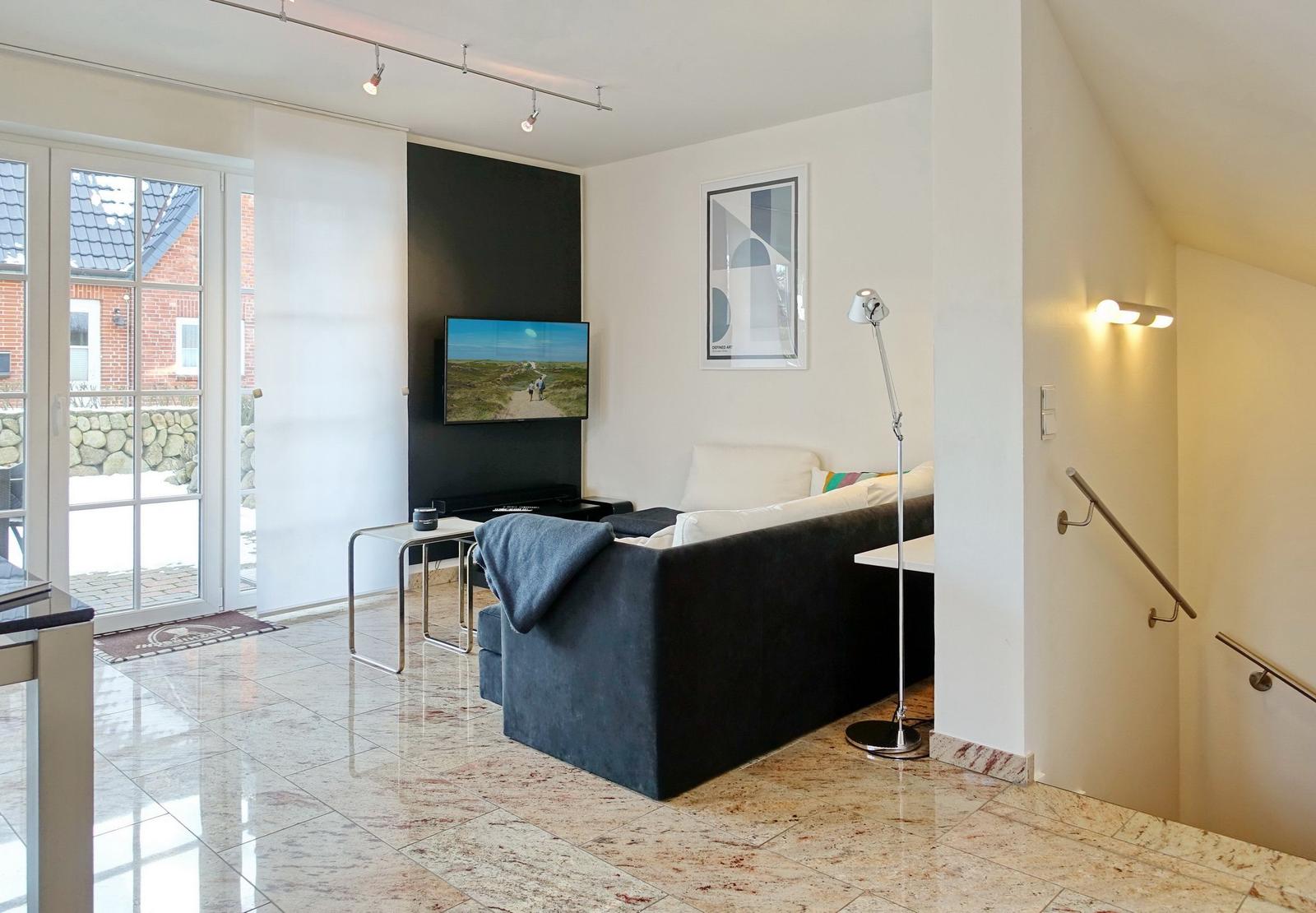 Living room with sofa, TV, and terrace door.