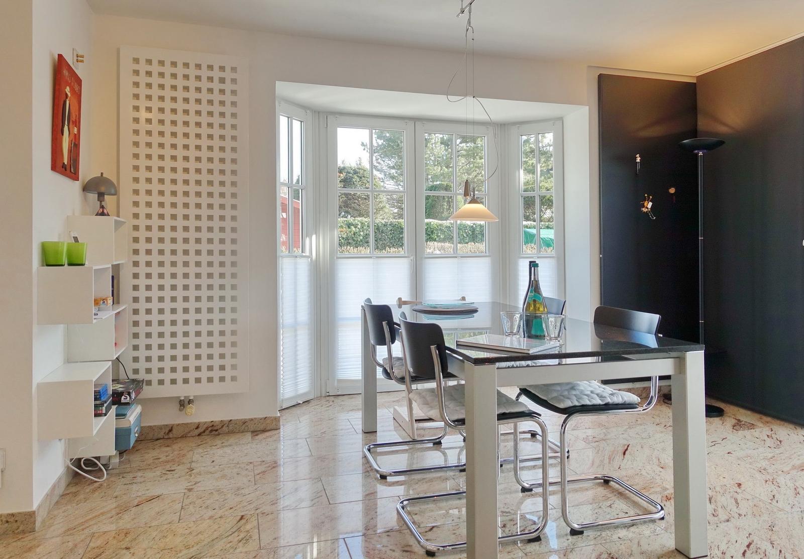 Dining room with glass top, chairs, and windows to the outside.