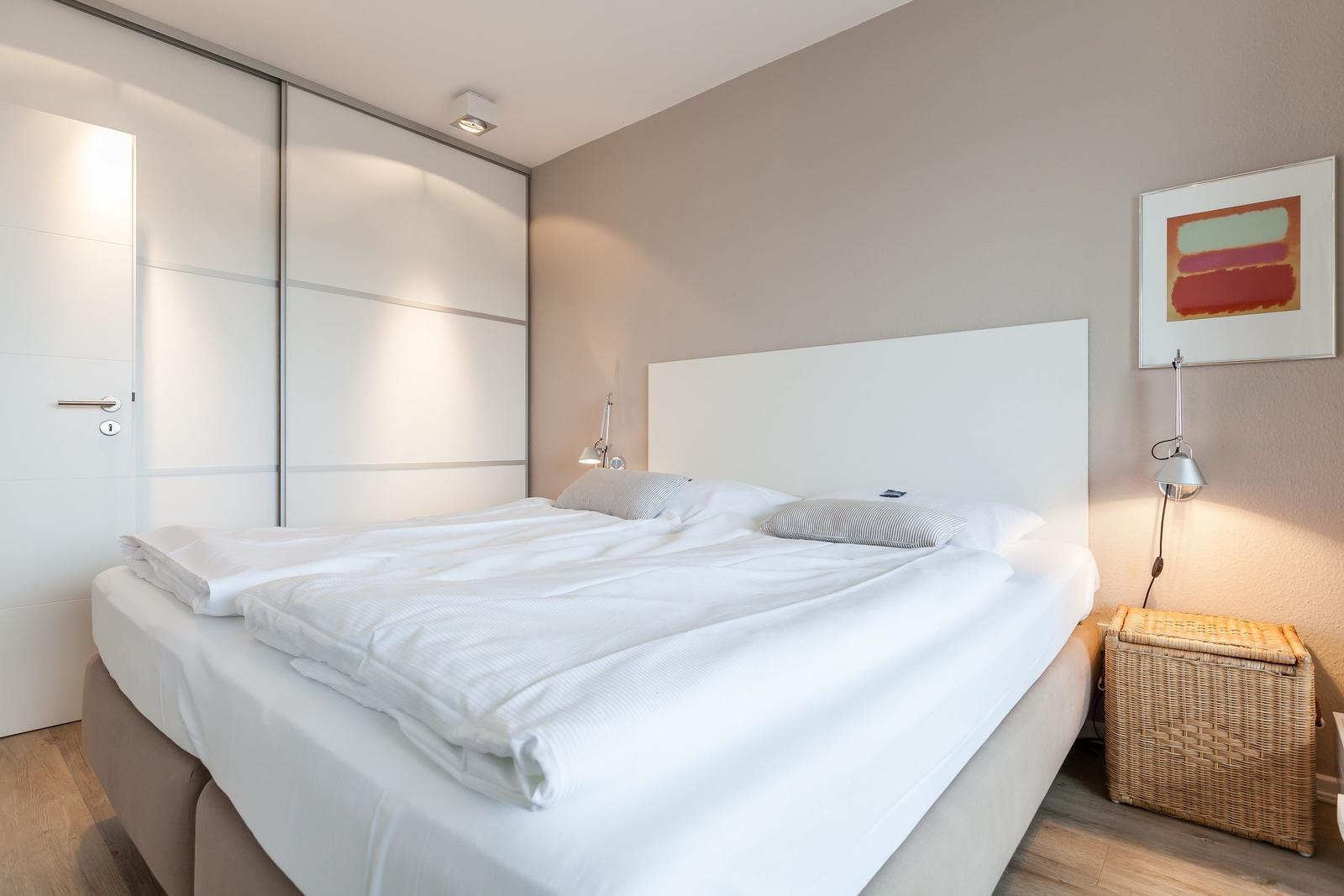 Bedroom with double bed, sliding doors, and wall art.