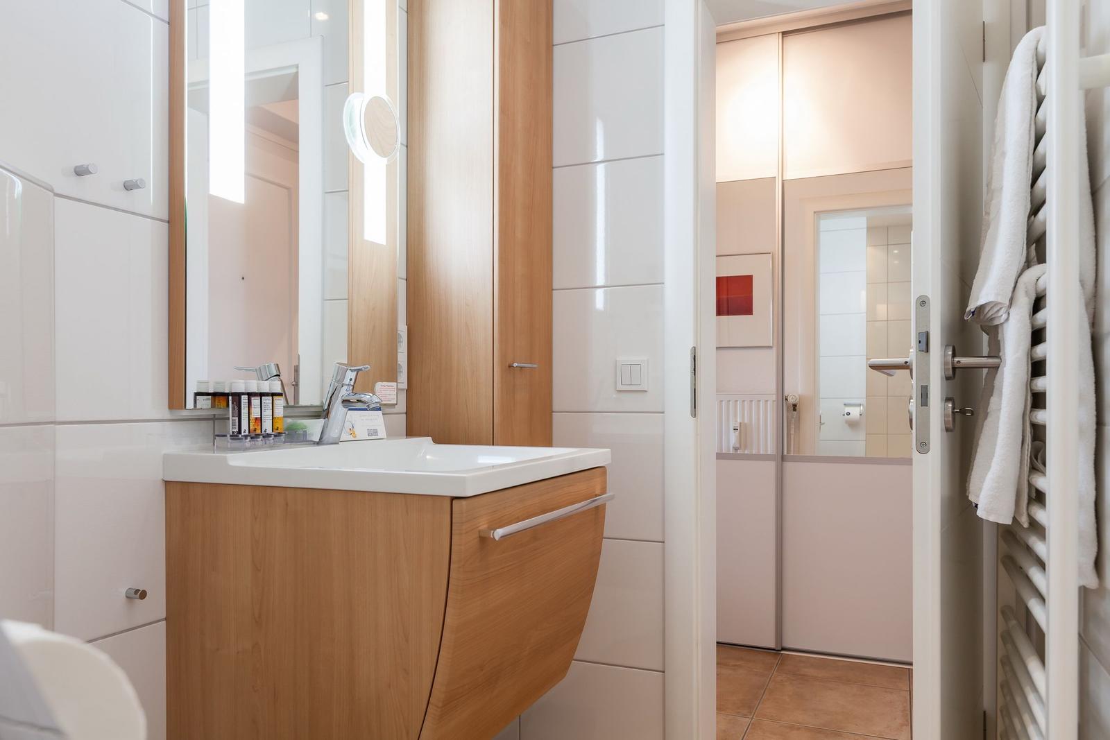 Bathroom with sink, mirror, and towel warmer
